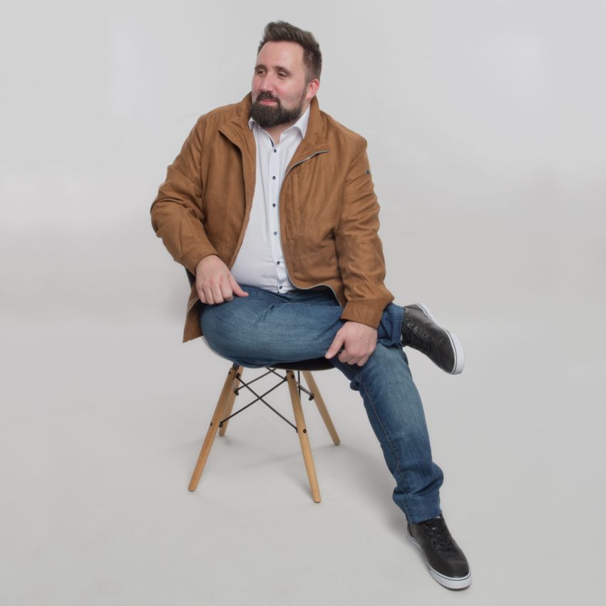 Look casual chic composé d'un jean, une chemise blanche, un blouson suédine camel et d'une paire de baskets noires.